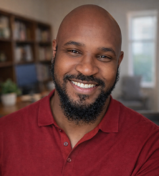 Portrait of Corey Weathers smiling in a red shirt.